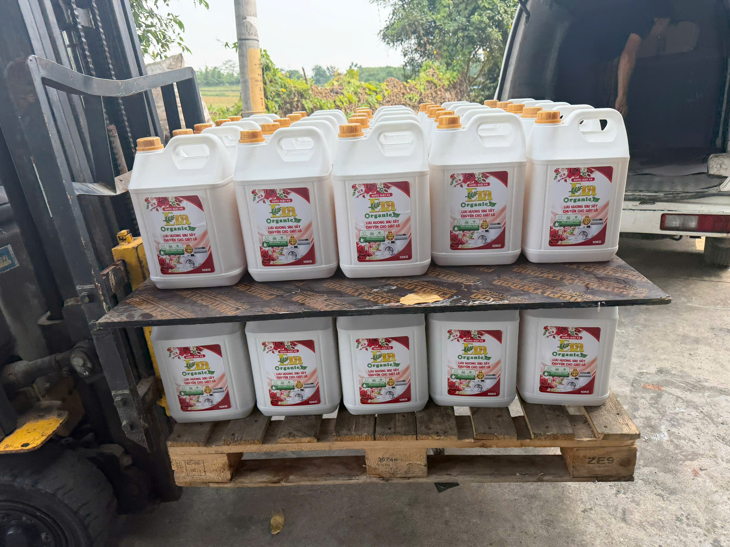 Xe nâng đưa pallet can nước giặt gia công lên xe giao hàng